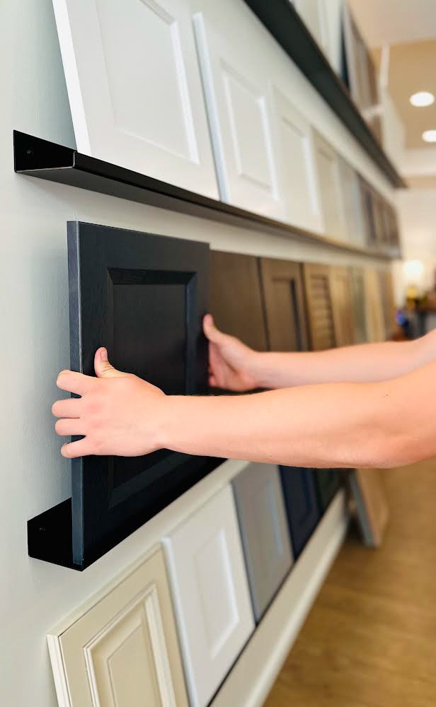 Cabinet door finishes being compared by hand