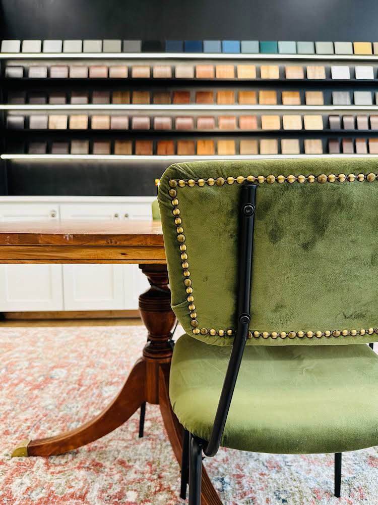 Olive chair beside material displays in The Design Center showroom